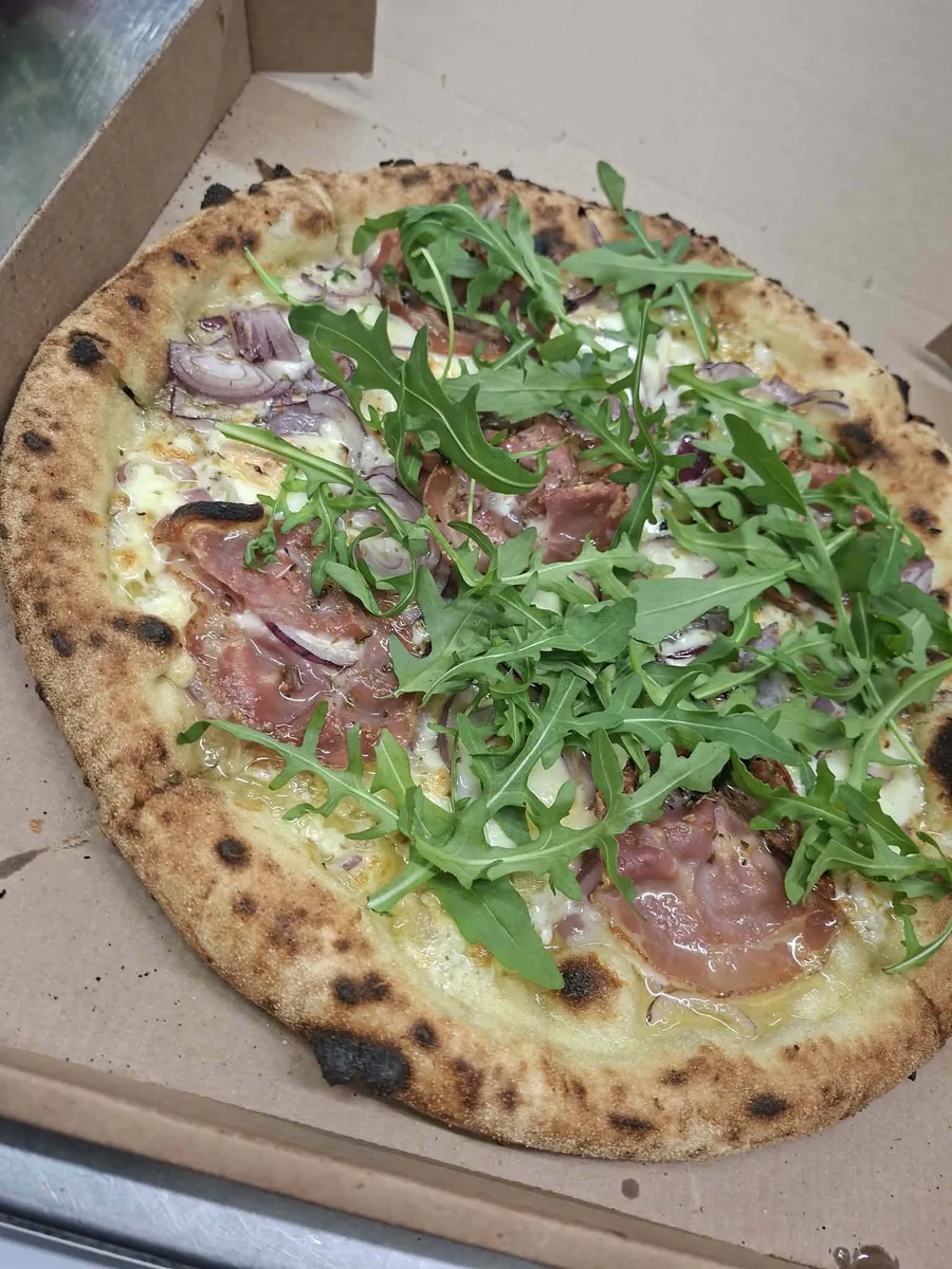Pizza aux scampi, tomates cerises et roquette fraîche